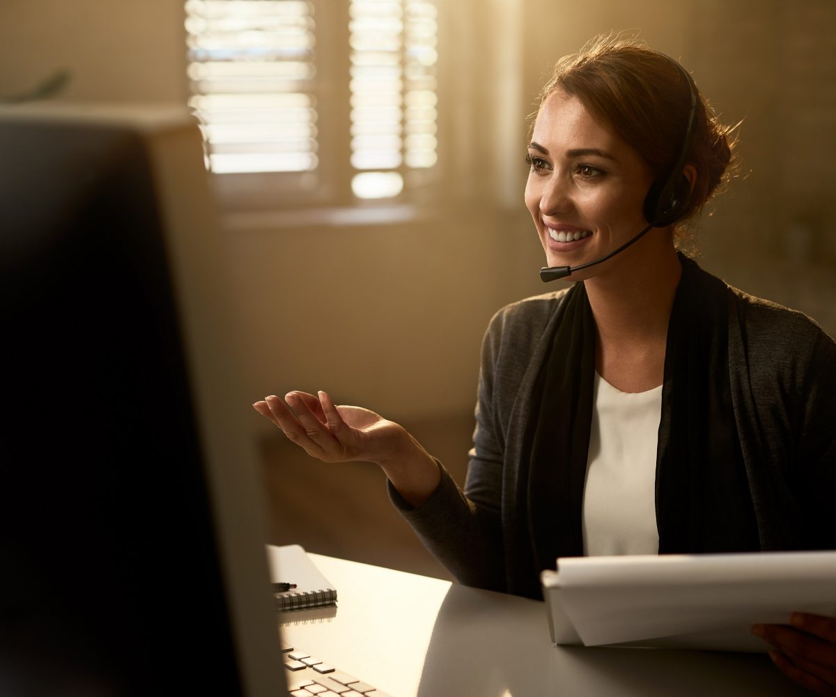 Young happy businesswoman having a video call over desktop PC while working in the office.